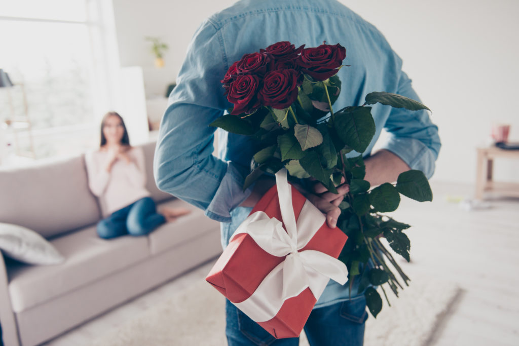 man surprising his partner with flowers